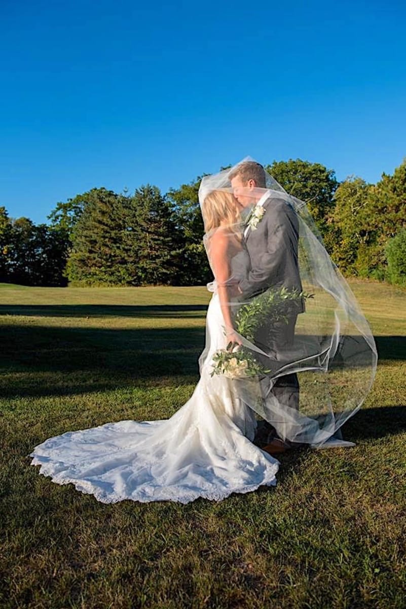 Bride and Groom kissing on the lawn.