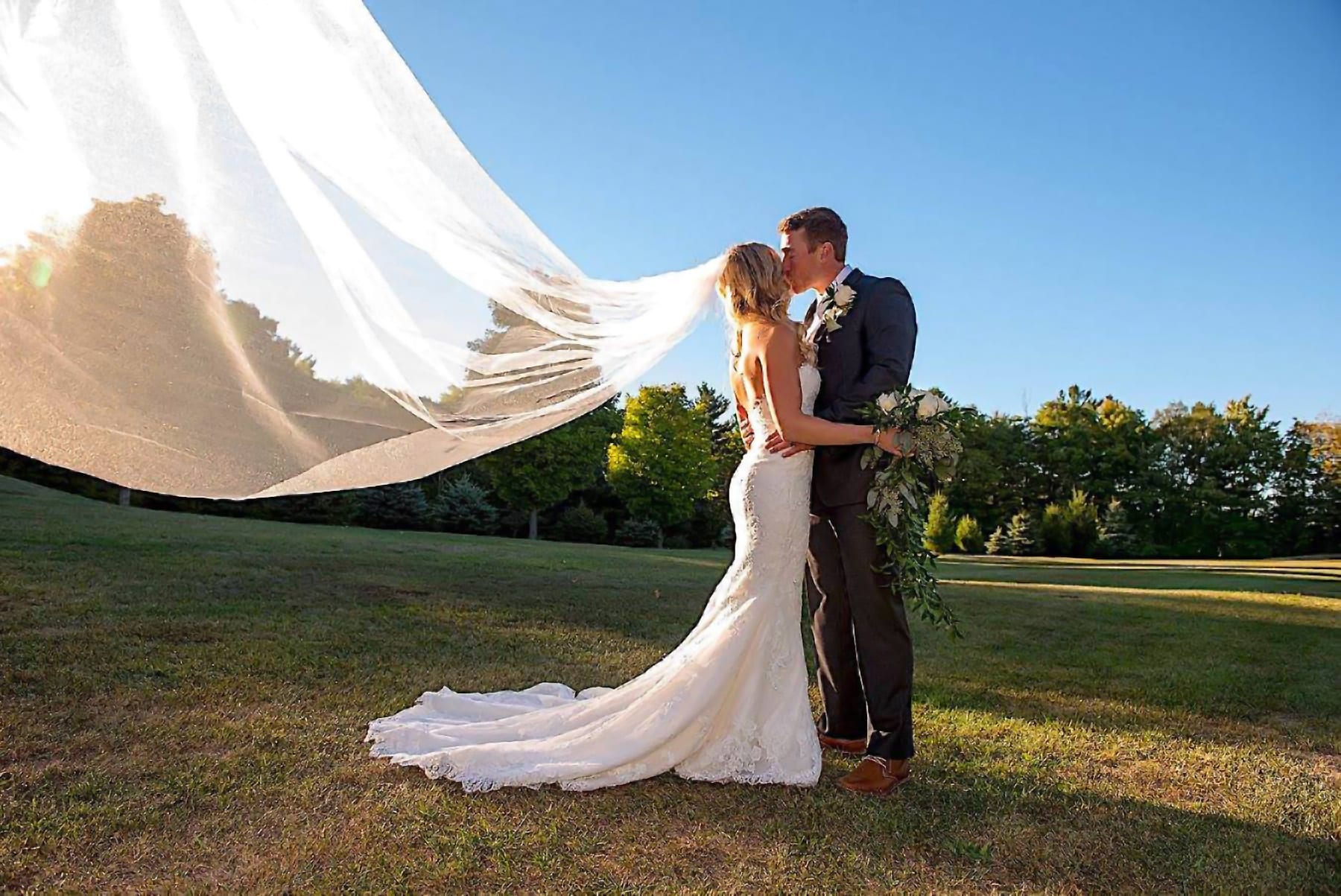 Bride and Groom kissing on a lawn.