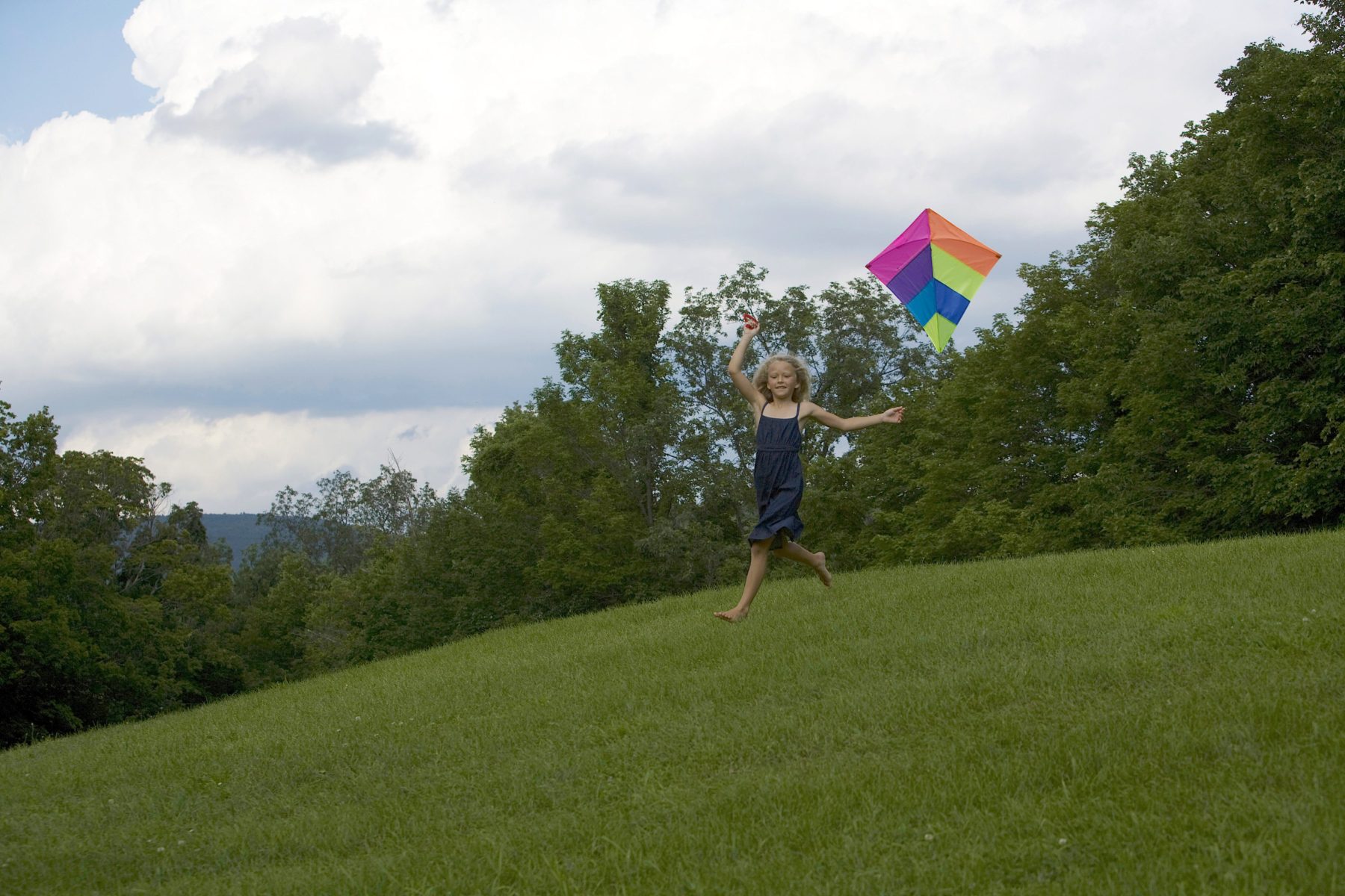 Girl running with a kite.