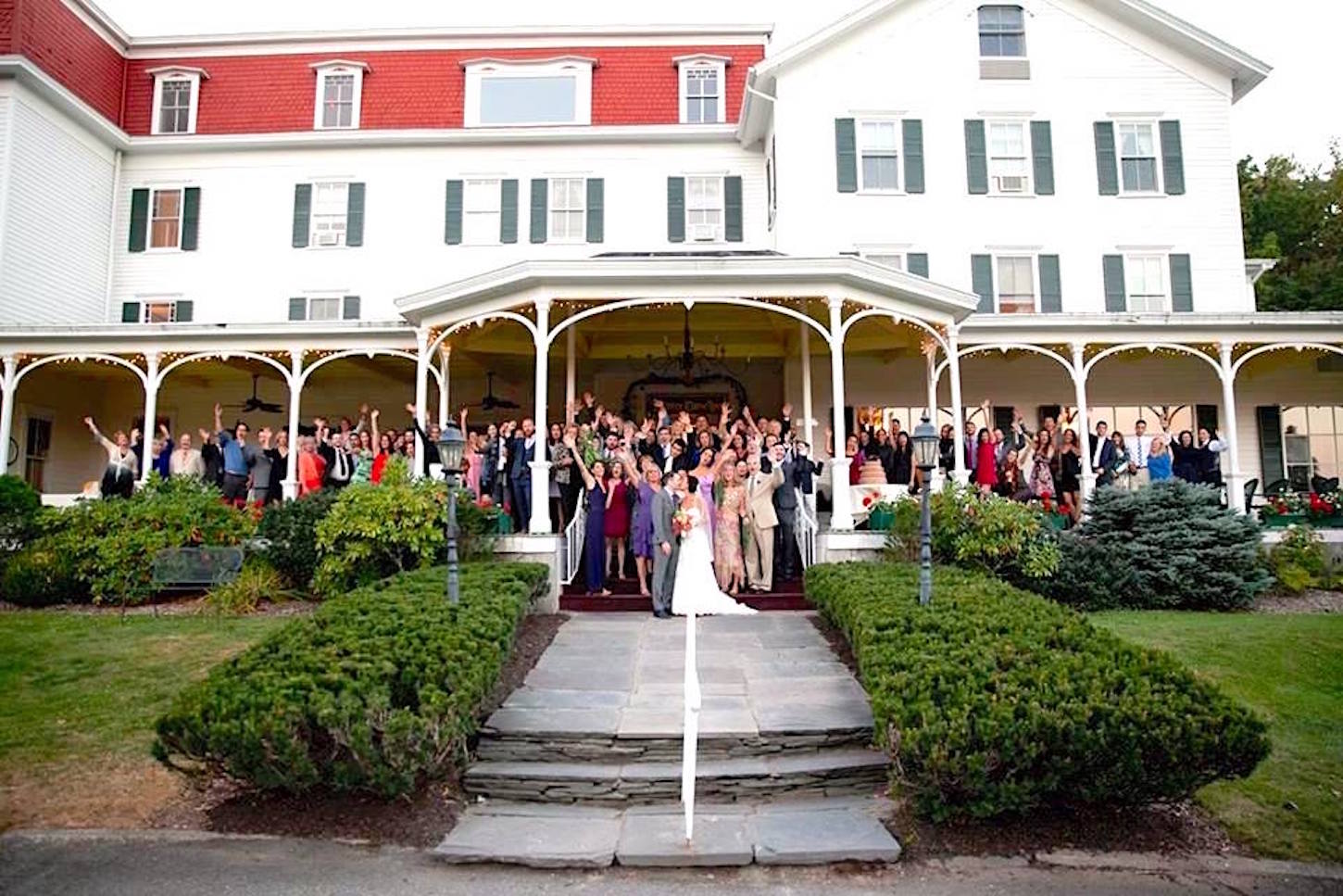 Wedding party and guests standing on the patio and steps.