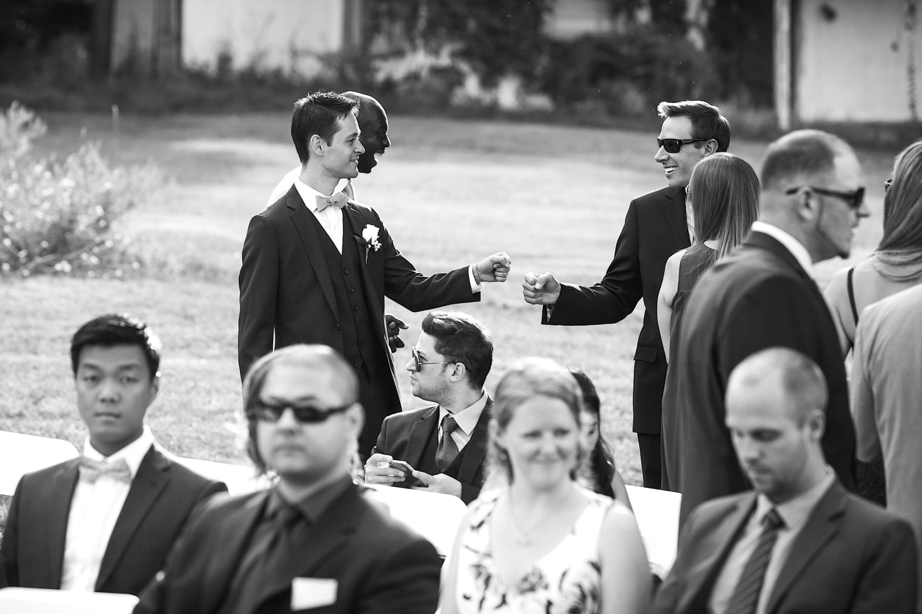 Groomsman and guest fist bumping.